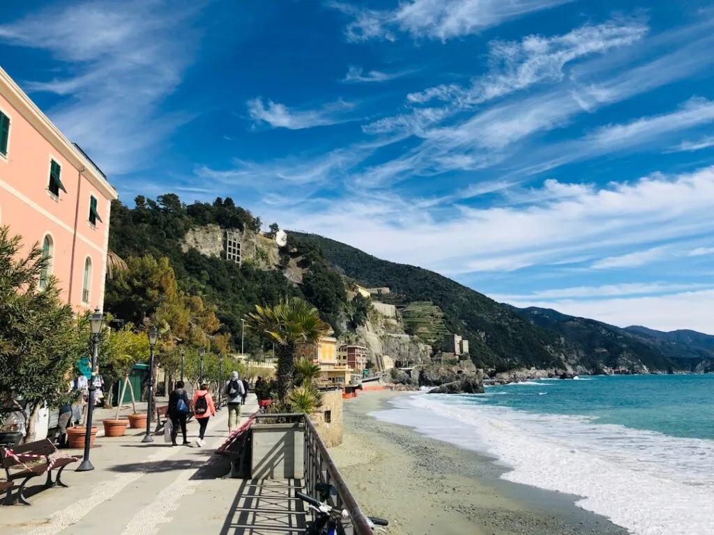 Promenade côtière animée à Cinque Terre, plage et falaises en arrière-plan
