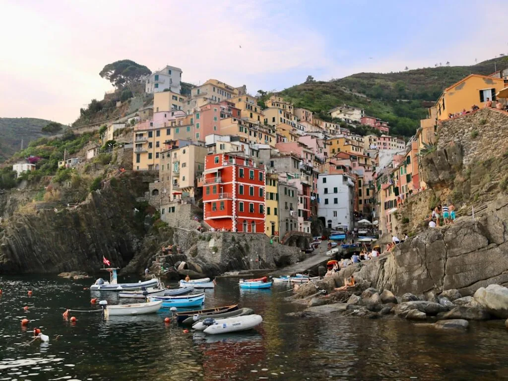 Port animé avec bateaux et façades colorées à Riomaggiore, Cinque Terre