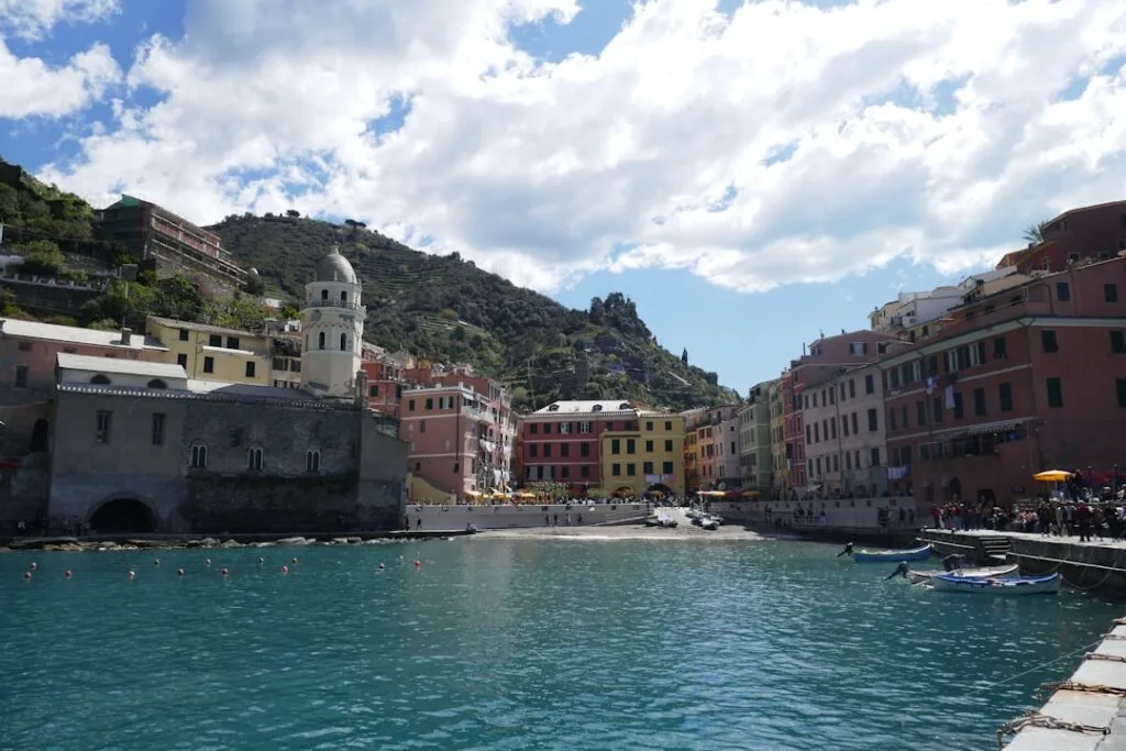 Port de Vernazza avec maisons colorées, église et eau turquoise.