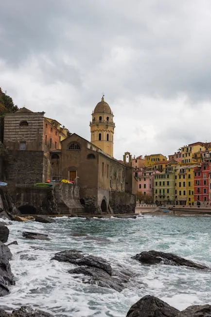 Clocher et bâtiments anciens au bord de la mer agitée à Vernazza