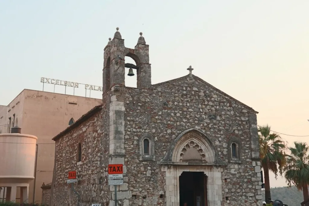 Église en pierre avec clocher et panneaux 'TAXI', Cinque Terre.