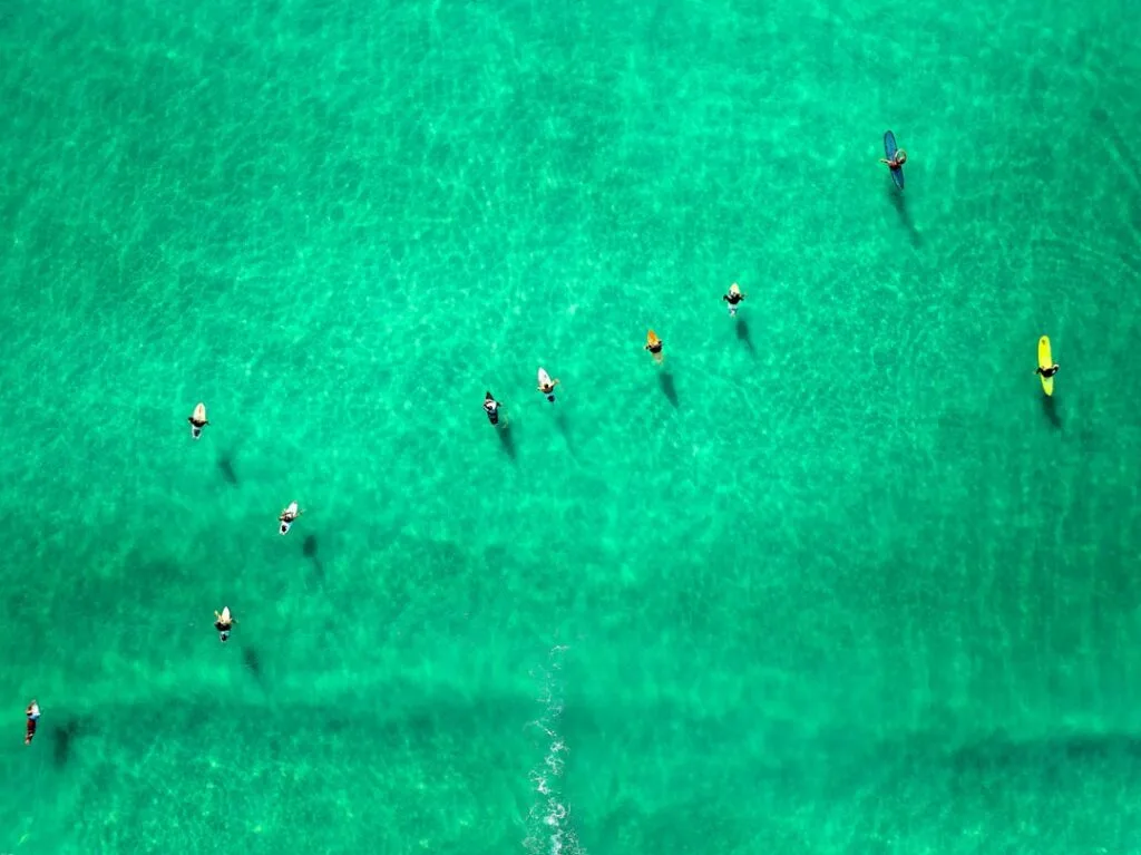 Stand-up paddleurs alignés sur une mer turquoise, vue aérienne, Cinque Terre.
