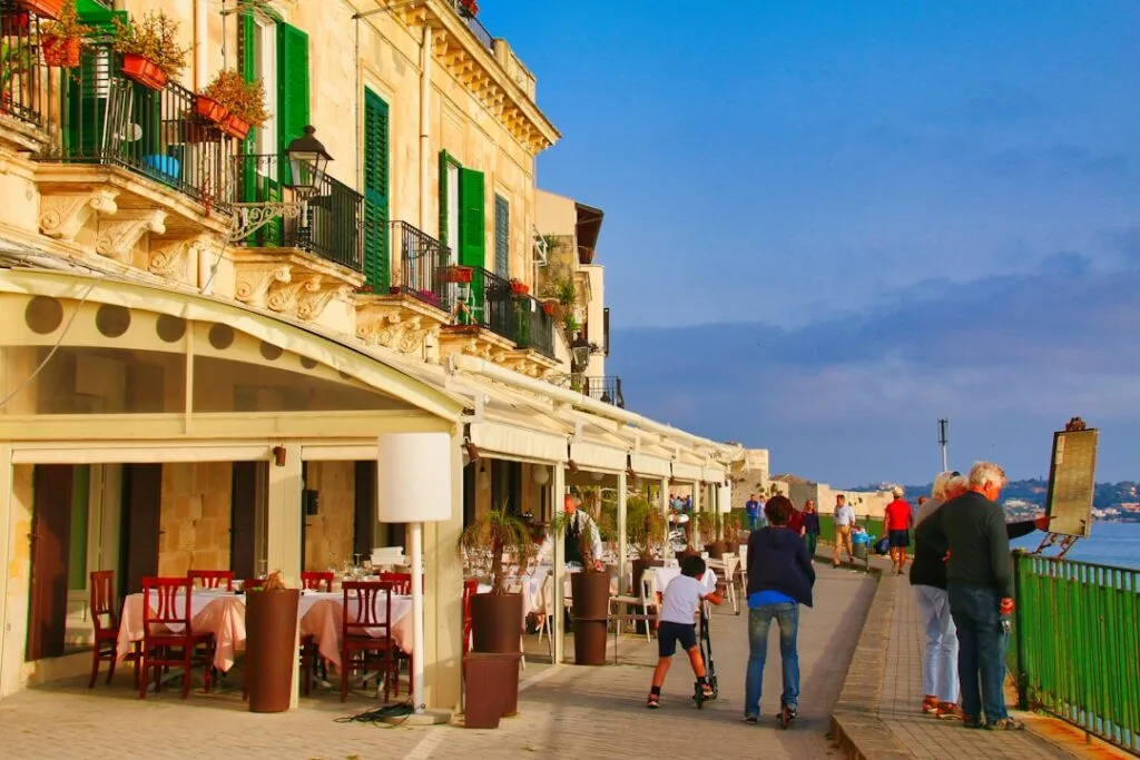 Promenade en bord de mer avec restaurants et familles se promenant