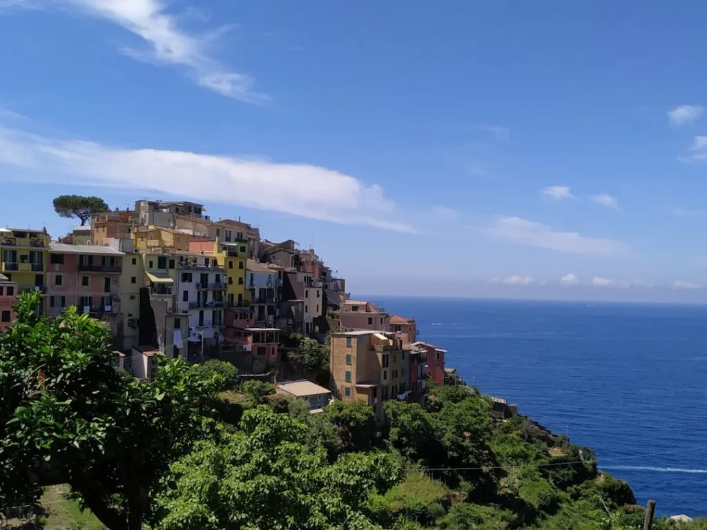 Maisons pastel accrochées à la falaise des Cinque Terre, mer bleue
