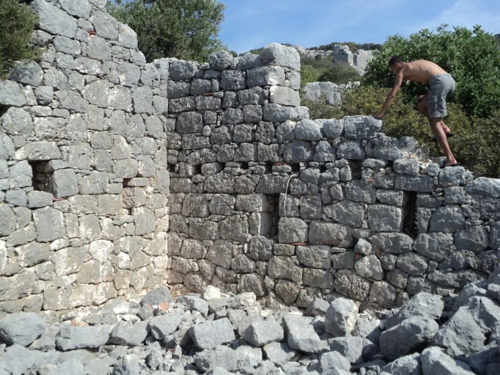 Vestiges en pierres dans l'arrière-pays des Cinque Terre, un homme escalade