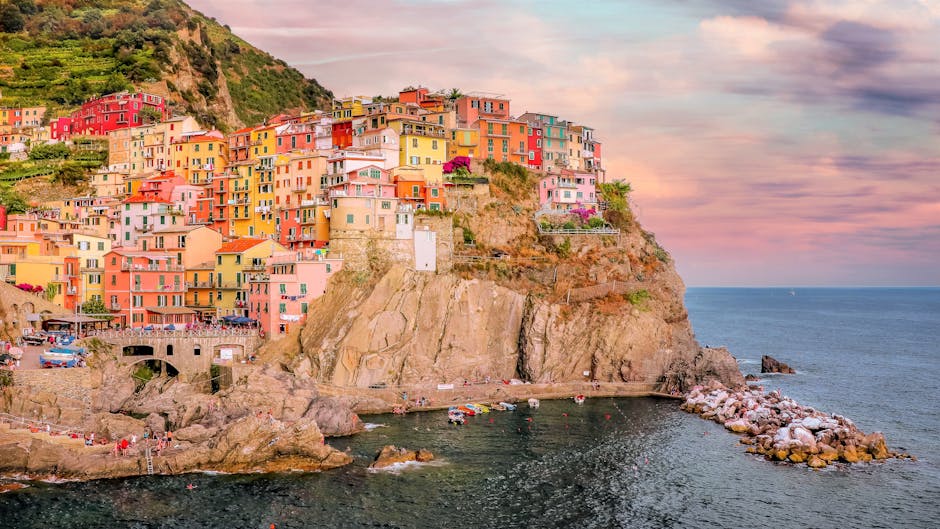 Colorful Cinque Terre houses perched on rocky cliff above sea.