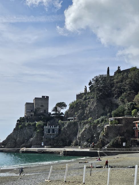 Ancienne tour sur falaise dominant une plage tranquille des Cinque Terre