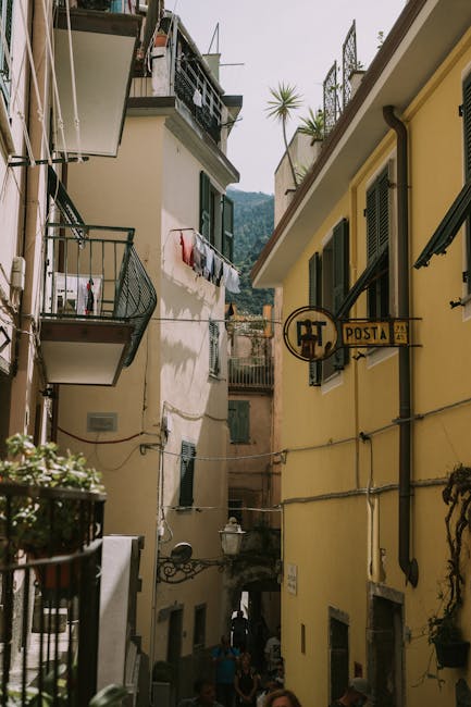 Narrow Cinque Terre alley with laundry lines and vintage Posta sign.
