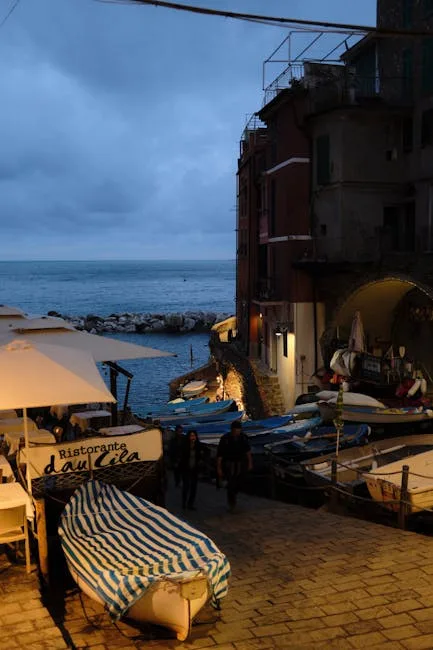 Kleine boten en terras met parasols bij haveningang in Cinque Terre