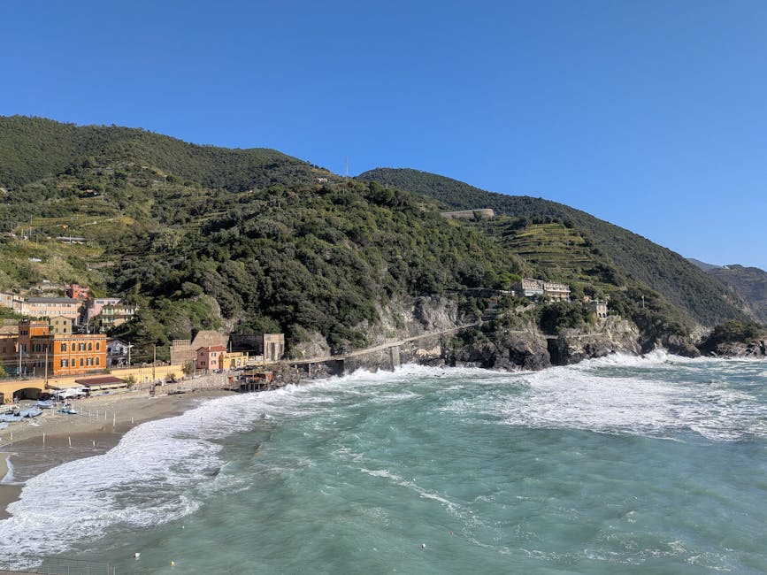 Falaises verdoyantes, plage et vagues puissantes sur la côte des Cinque Terre