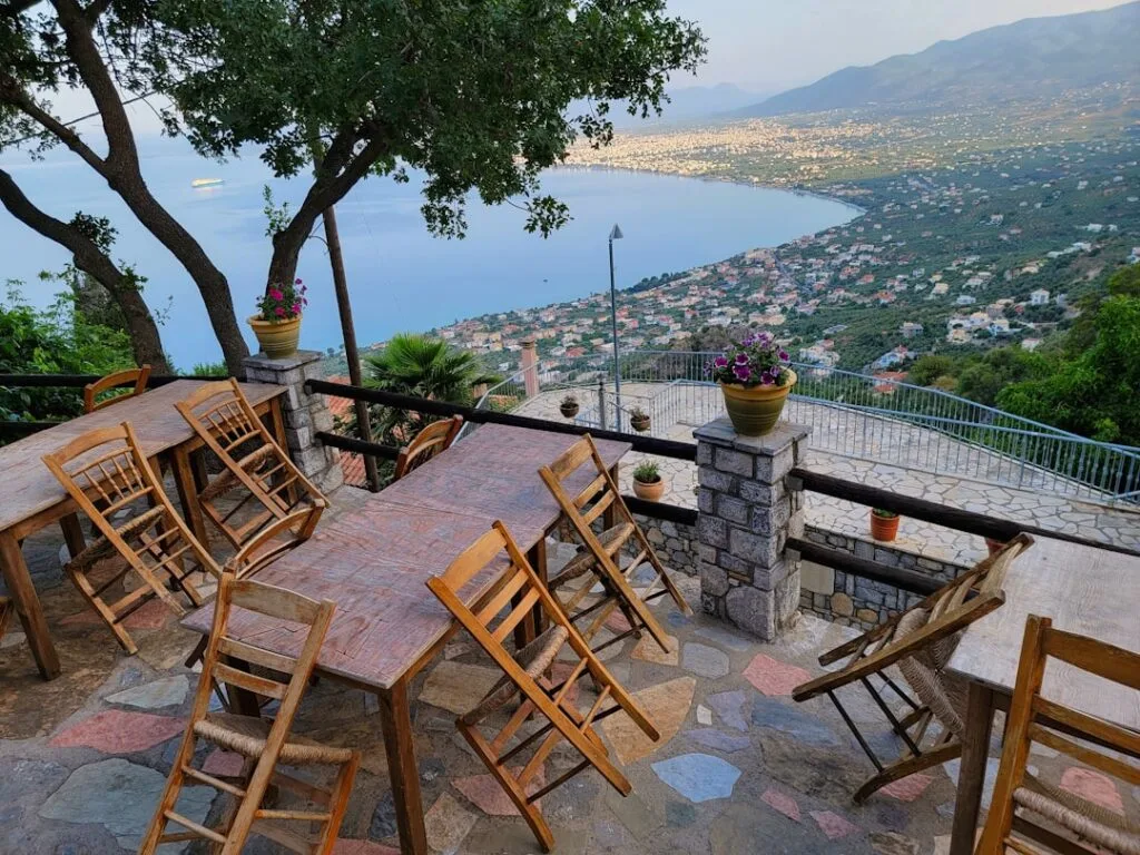 Terrasse ensoleillée avec tables et chaises donnant sur la baie de Cinque Terre