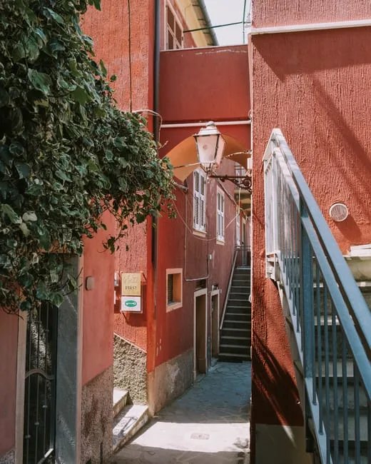 Ruette étroite à façades rouges et escaliers typiques des Cinque Terre