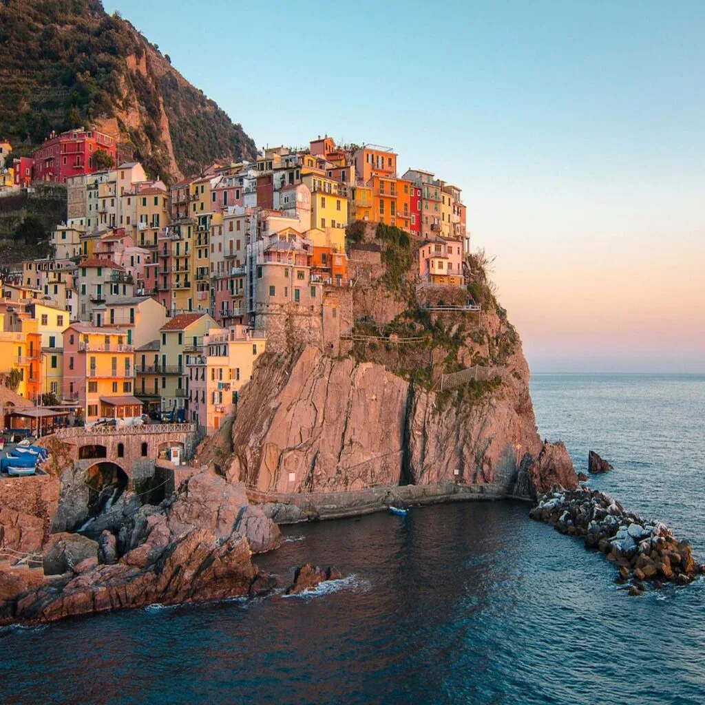 Falaises et maisons pastel baignées par le soleil couchant à Cinque Terre