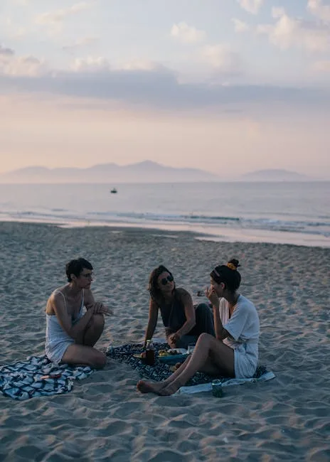 Trois personnes assises sur une plage au crépuscule près de Cinque Terre