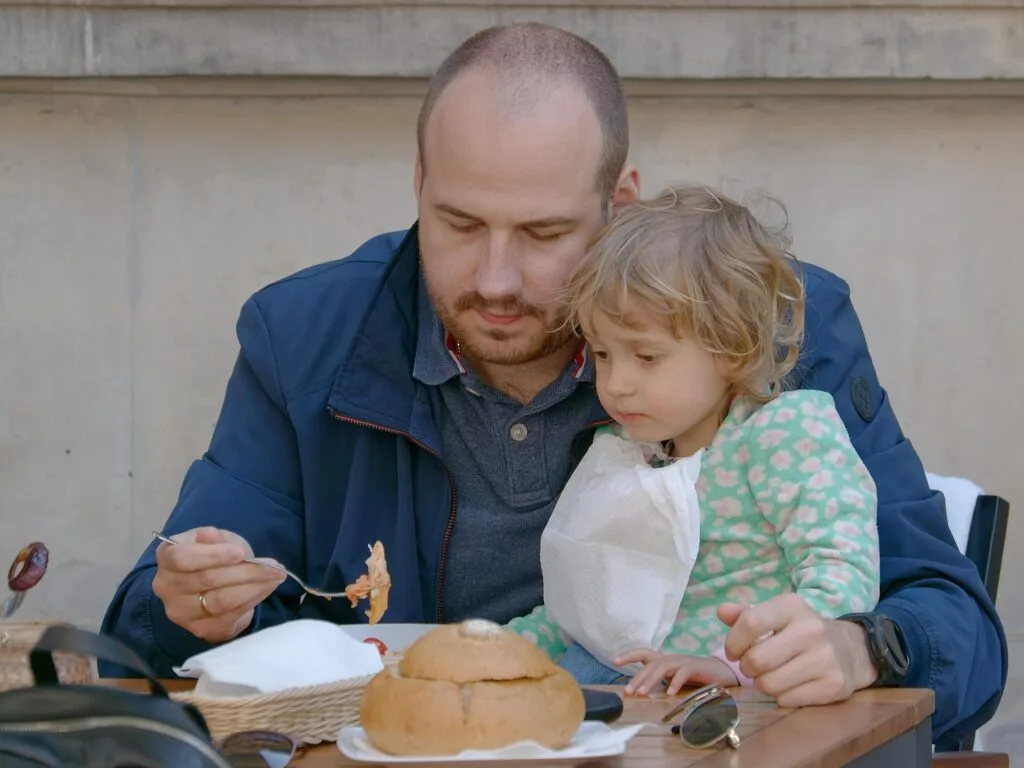 Père donnant à manger à son enfant en terrasse à Cinque Terre