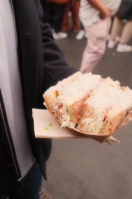 Kanapka L'As du Fallafel na ławce w Marais, zatłoczona ulica