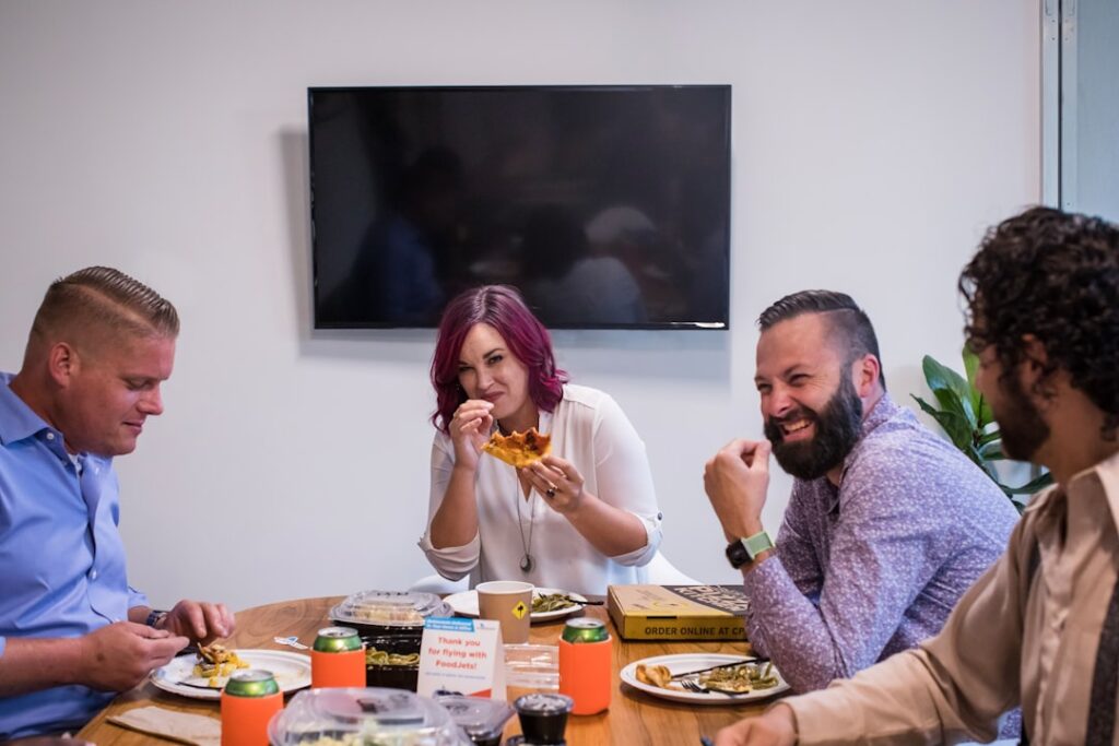 Pracownicy biurowi jedzący szybki lunch w nowoczesnej kantynie