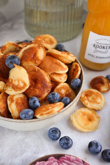 piattino di poffertjes fumanti con zucchero a velo