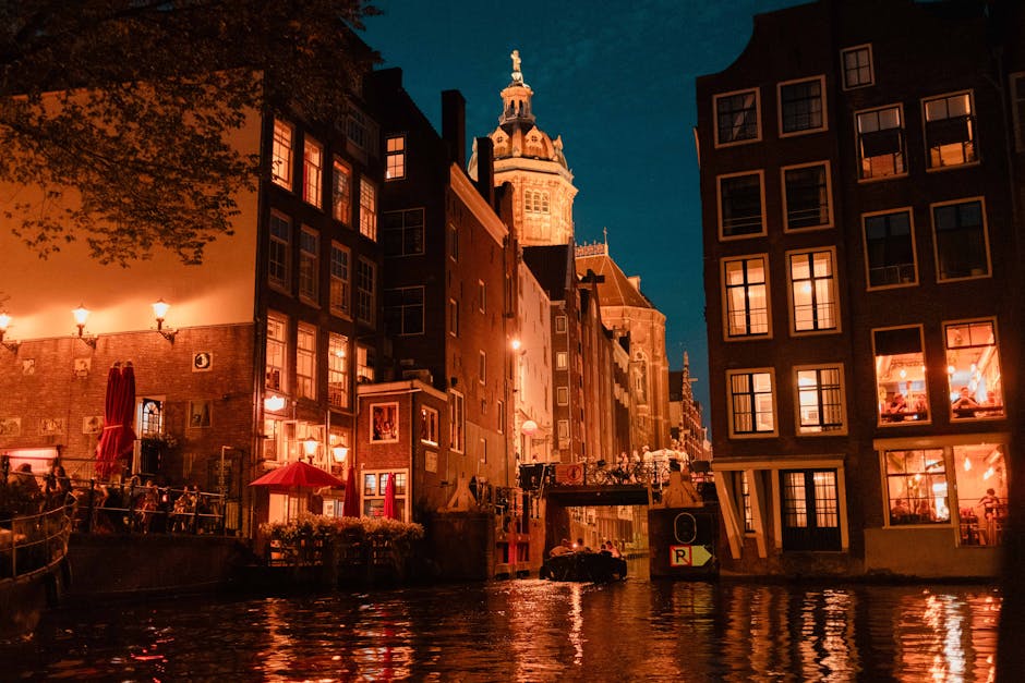 Evening canal view with festival lights and tourists in Amsterdam