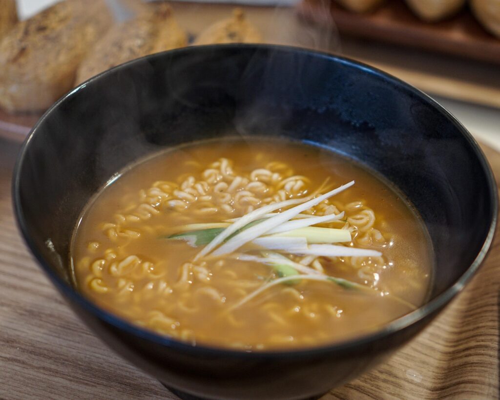 piccola ciotola di ramen fumante e dumplings in un interno accogliente