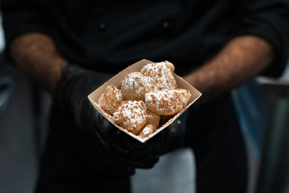 venditore ambulante che serve poffertjes con zucchero a velo