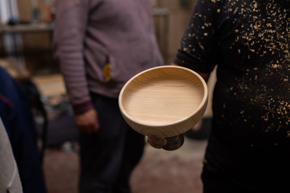Artisan handing a handcrafted wooden bowl to a customer in a workshop