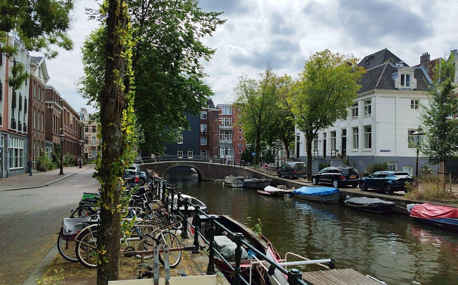 Rodzina na rowerach po ścieżce w Amsterdamie wzdłuż kanału