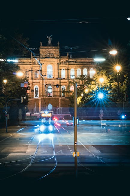 Long exposure of a tram passing a theater at night