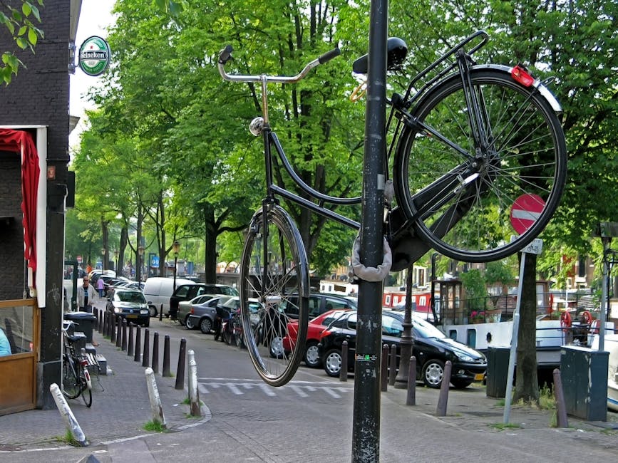 Fiets op slot met twee sloten bij een gracht in Amsterdam