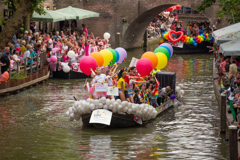Canal parade boats colorful crowd during Amsterdam Pride