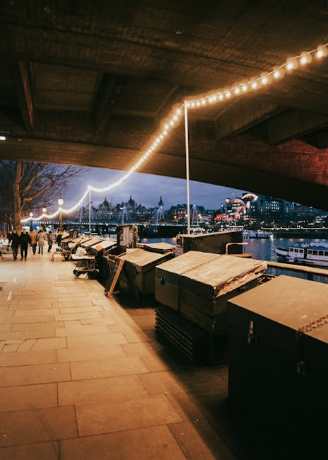 Loopbrug bij London Bridge richting Globe Theatre in avondverlichting