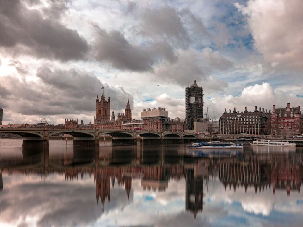 Tower Bridge illuminato al mattino presto con riflessi sul Tamigi