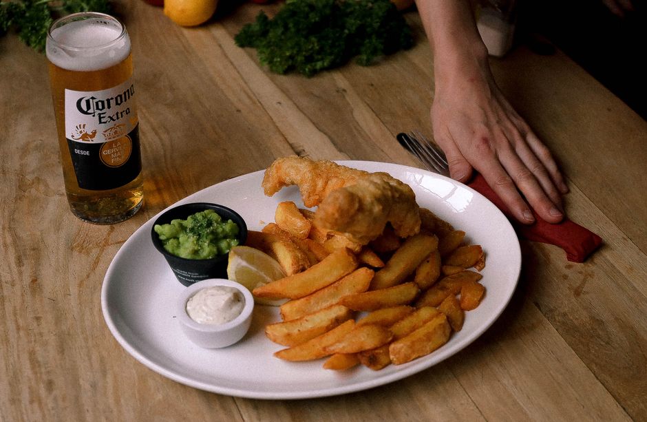 Innenansicht eines East End Pubs mit Holztischen und Fish & Chips