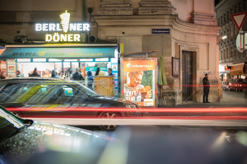beleuchtete Berliner Straße am Abend mit Gästen