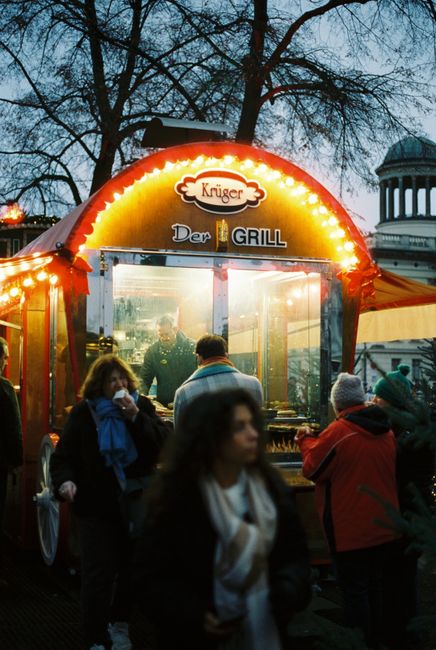 Late-night street food stall at a Berlin festival with a crowd