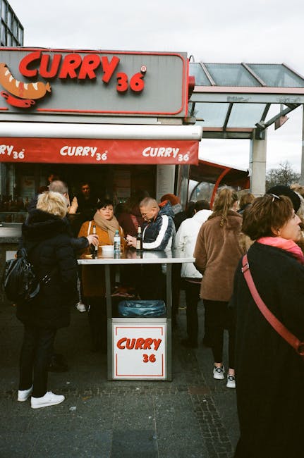 Verkäufer bei Curry 36 schneidet die Wurst