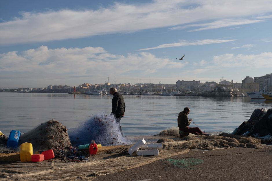 Local fisherman mending nets on Fisherrow Harbour quay