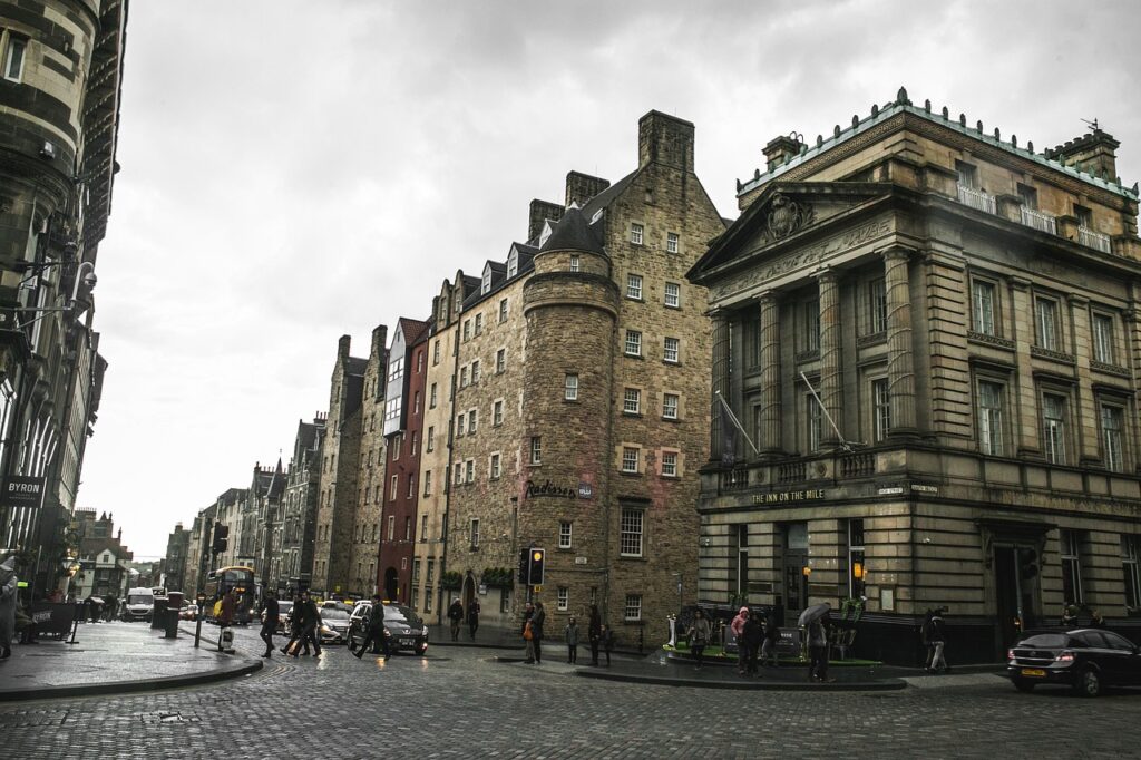 Regnerische Royal Mile mit Kopfsteinpflaster und historischen Gebäuden bei Abendlicht
