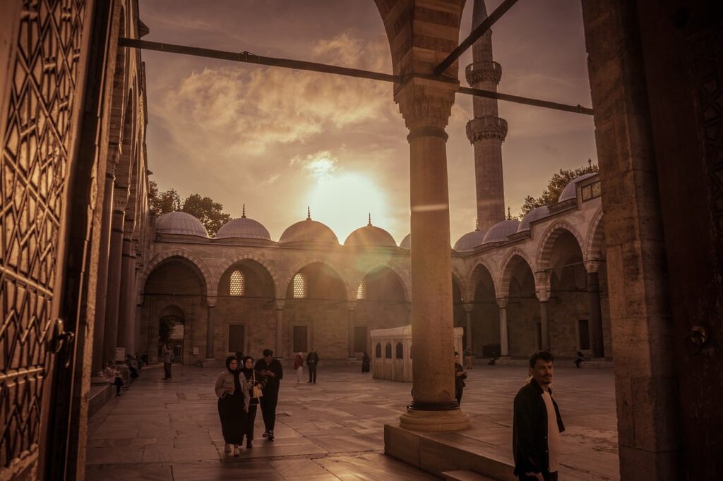 Cortile della Moschea Blu al tramonto con luce calda e visitatori