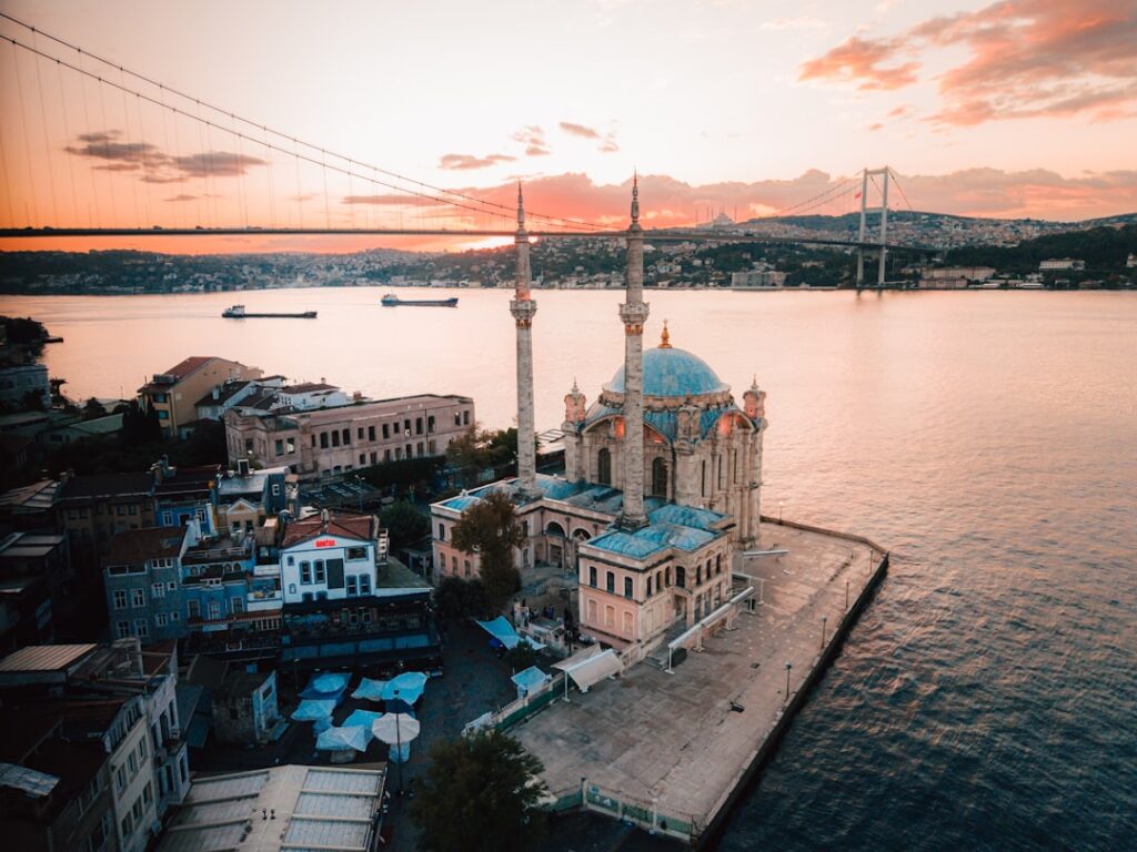 Moschea di Ortaköy sul Bosforo all’ora dorata con barche che passano
