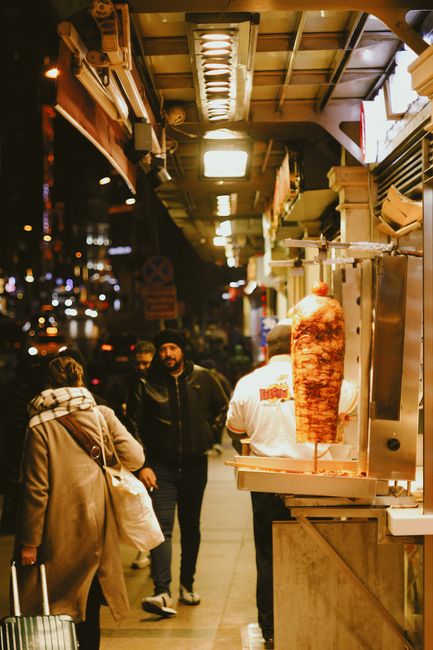 Straßenverkäufer schneidet Döner neben belebter Istanbuler Tram