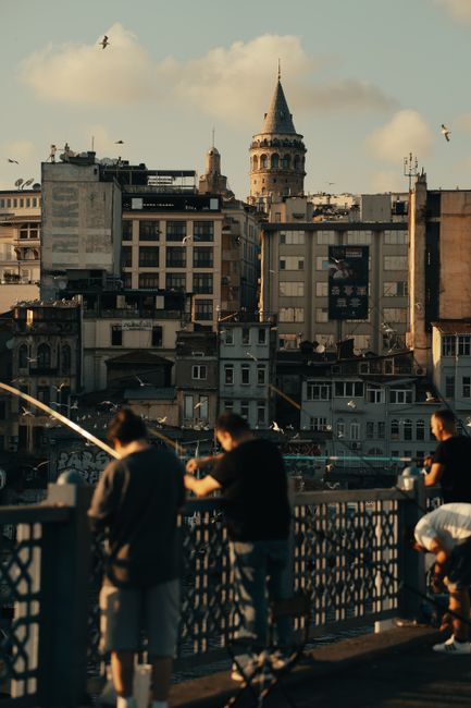 Galata Bridge with fishermen and the city skyline at dusk