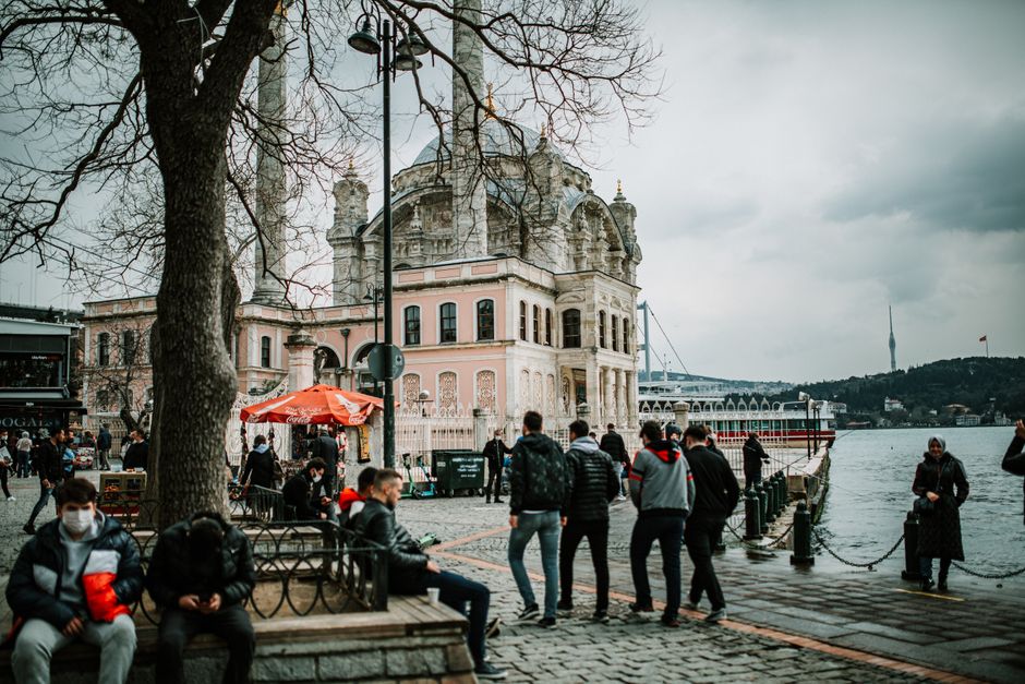 Ortaköy Mosque by the Bosphorus with a vendor serving kumpir