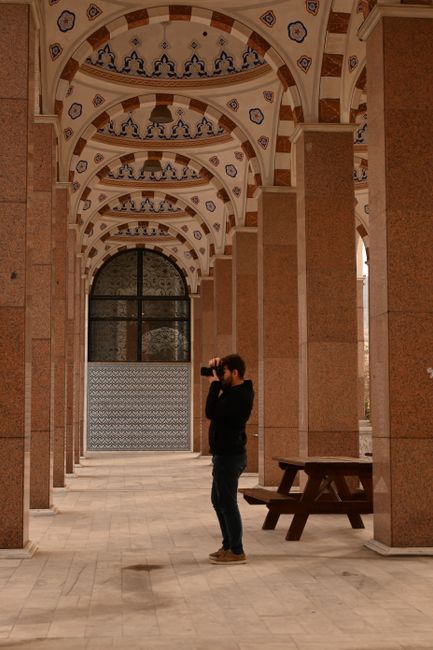 Photographer taking street photos near a historic mosque entrance
