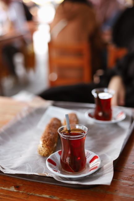 Turkish tea served with simit and baklava on a seaside table