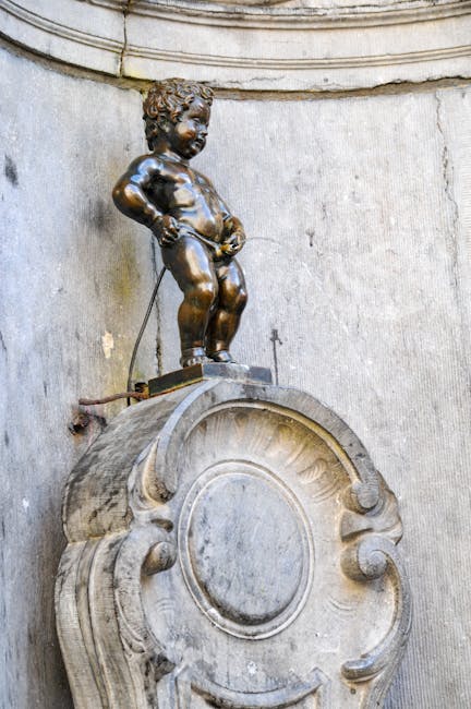 Manneken-Pis, mała brązowa statua wśród turystów