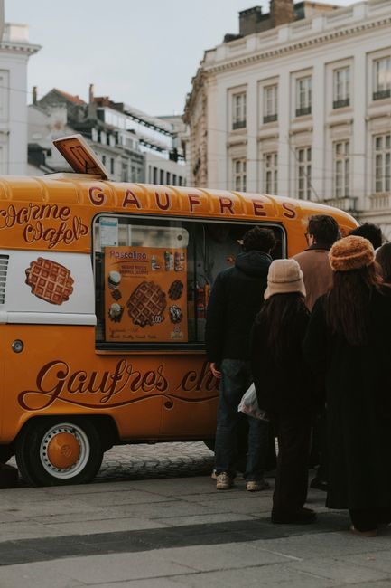 Touristen folgen einer Streetfood-Route in Brüssel und genießen Essen
