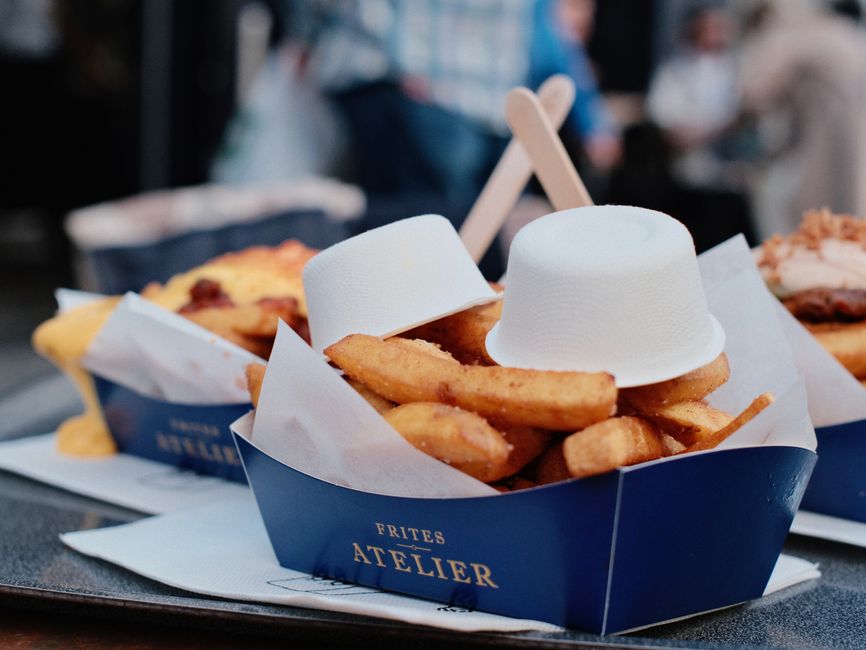 Besucher an einer Frittenbude am Flagey-Platz, Leute essen draußen Pommes