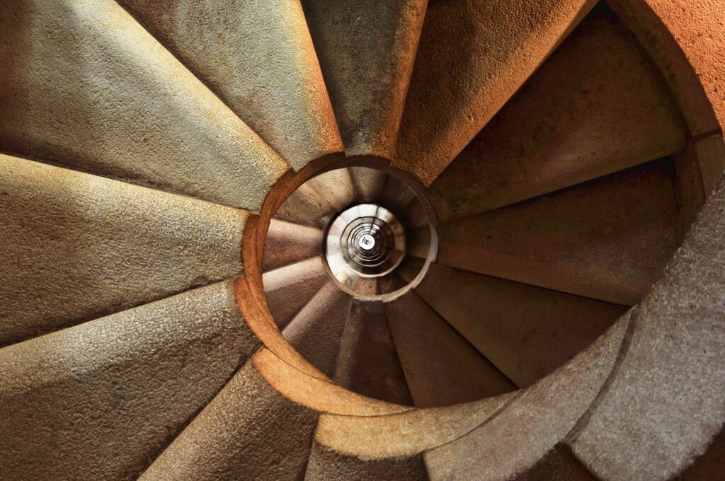 Visitatore che percorre una stretta scala di pietra all’interno del palazzo