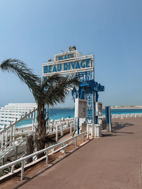 Openbaar kiezelstrand Beau Rivage, zwemmers en blauwe lucht